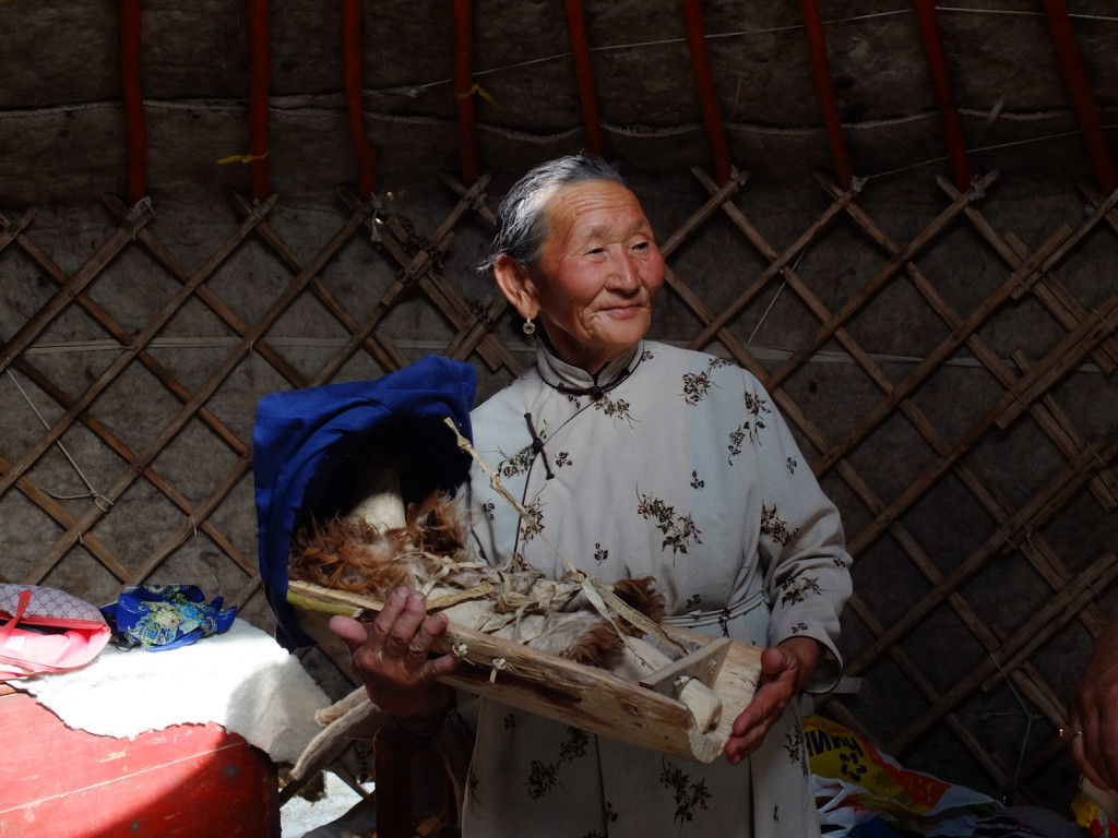 A woman shows us how babies were traditionally carried. This was a yurt set up traditionally for demonstration.